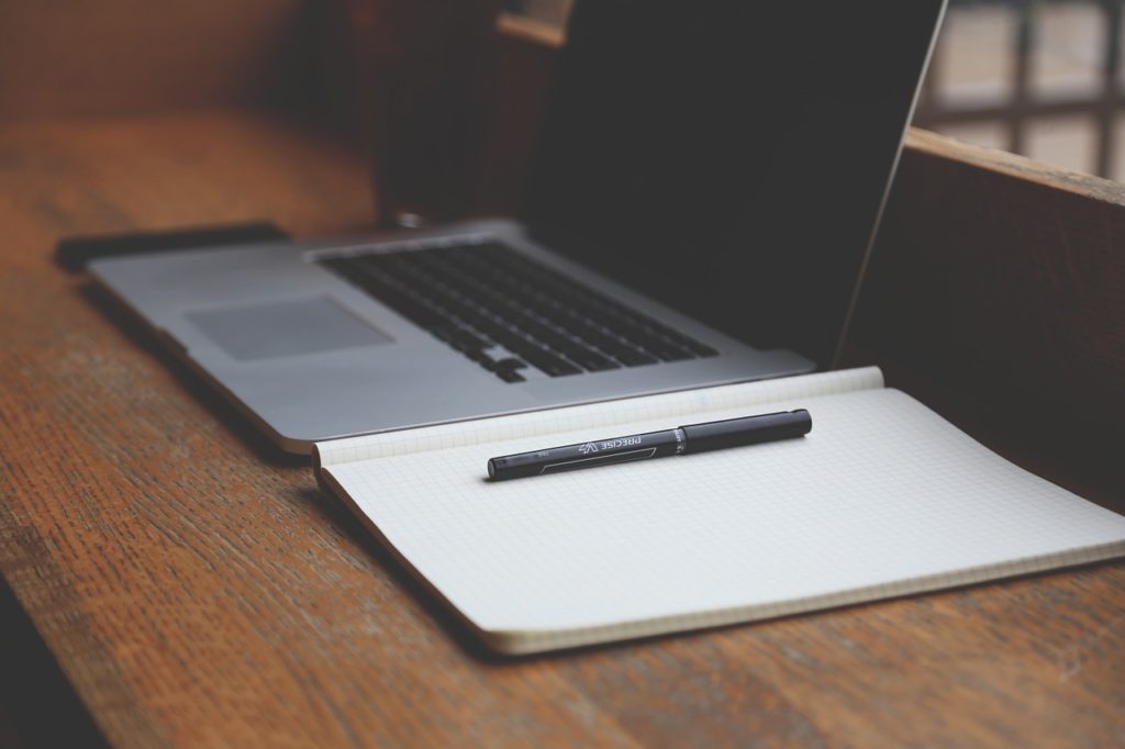 ordinateur, papier et crayon pour la rédaction web - Webmaster Morbihan petit budget