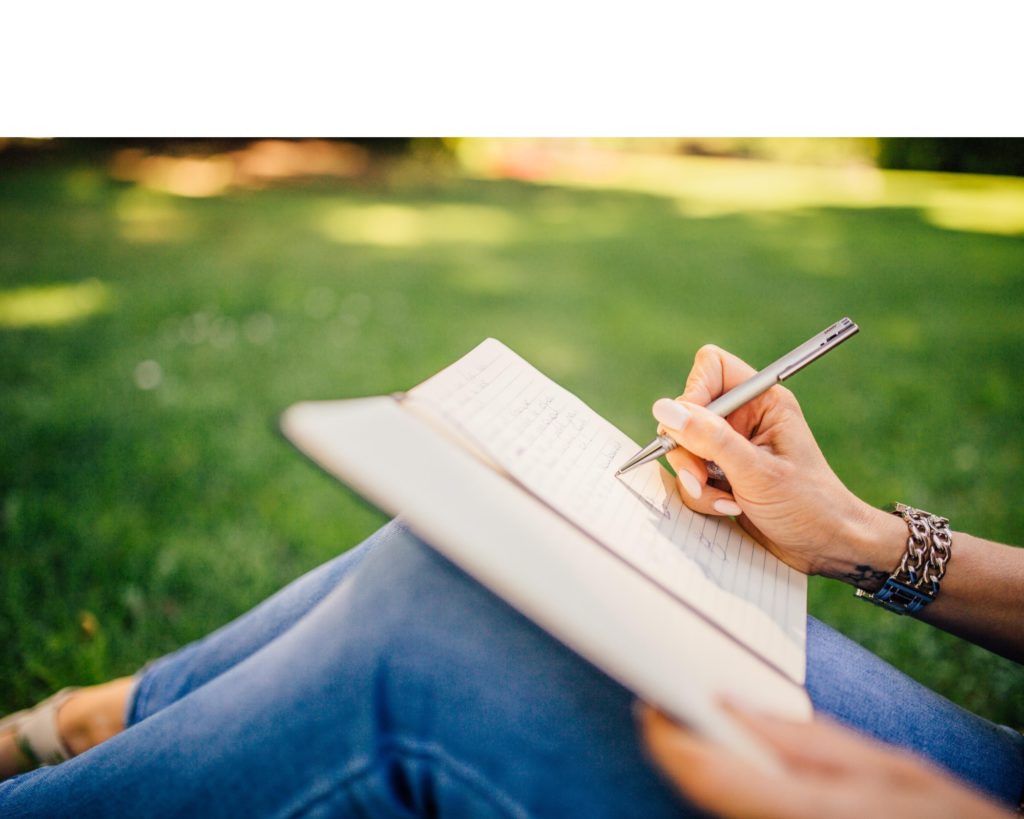 Femme qui écrit dans un parc - Rédaction et rédaction web par Erialla Communication