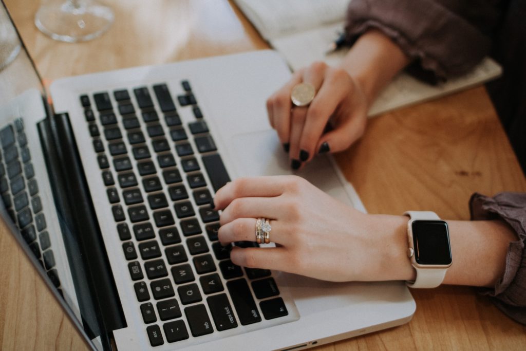 Femme écrivant sur ordinateur - Rédaction et rédaction web par Erialla Communication